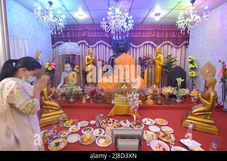 (220515) -- DHAKA, 15. Mai 2022 (Xinhua) -- Eine Frau betet vor einer großen Buddha-Statue während der "Buddha Purnima"-Feier in Dhaka, Bangladesch, am 15. Mai 2022. Buddhisten feierten am Sonntag in Bangladesch „Buddha Purnima“, das die Geburt, Erleuchtung und den Tod von Gautama Buddha markiert. (Xinhua) Stockfoto