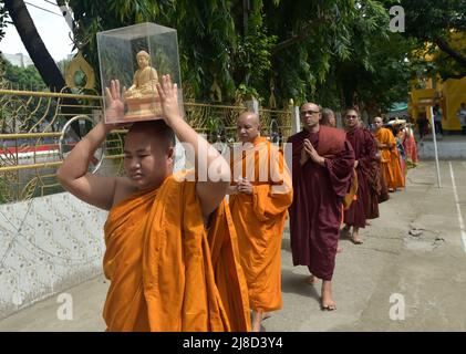 (220515) -- DHAKA, 15. Mai 2022 (Xinhua) -- Ein Mönch trägt eine Buddha-Statue während der "Buddha Purnima"-Feier in Dhaka, Bangladesch, am 15. Mai 2022. Buddhisten feierten am Sonntag in Bangladesch „Buddha Purnima“, das die Geburt, Erleuchtung und den Tod von Gautama Buddha markiert. (Xinhua) Stockfoto