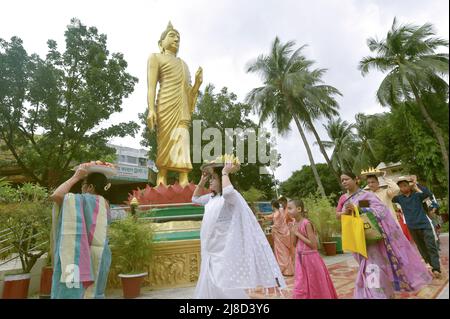 (220515) -- DHAKA, 15. Mai 2022 (Xinhua) -- Menschen, die Früchte auf ihren Köpfen tragen, werden während der "Buddha Purnima"-Feier in Dhaka, Bangladesch, am 15. Mai 2022 gesehen. Buddhisten feierten am Sonntag in Bangladesch „Buddha Purnima“, das die Geburt, Erleuchtung und den Tod von Gautama Buddha markiert. (Xinhua) Stockfoto