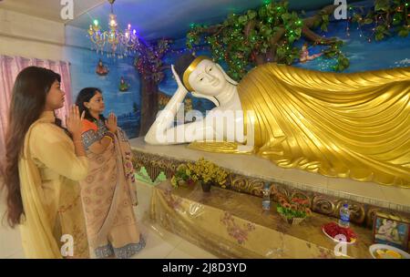 (220515) -- DHAKA, 15. Mai 2022 (Xinhua) -- Frauen beten vor einer großen Buddha-Statue während der "Buddha Purnima"-Feier in Dhaka, Bangladesch, am 15. Mai 2022. Buddhisten feierten am Sonntag in Bangladesch „Buddha Purnima“, das die Geburt, Erleuchtung und den Tod von Gautama Buddha markiert. (Xinhua) Stockfoto