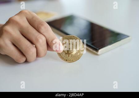 Kryptowährung ist digitale Währung, Frauen halten ihre Hände auf Computer-fertige Bitcoin-Münzen, um Vermögenswerte aus der digitalen oder imaginären Welt der zu investieren Stockfoto