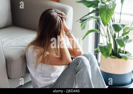 Unglückliche junge kaukasische Frau mit blonden Haaren Denken über schlechte Beziehungen Probleme, brechen mit Freund. Besorgt Millennial Mädchen sitzen auf Stockfoto