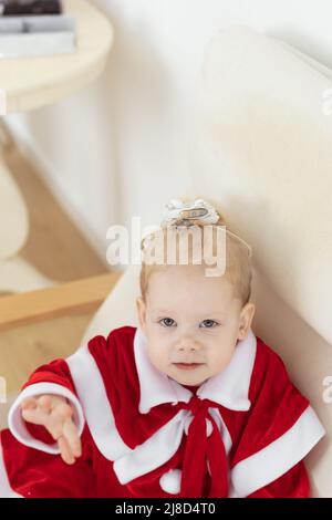 Kindermädchen in weihnachtskleid mit Cochlea-Implantaten gekleidet Spaß zu Hause - Hörgerät und innovative Technologien für die Behandlung von Taubheit Stockfoto