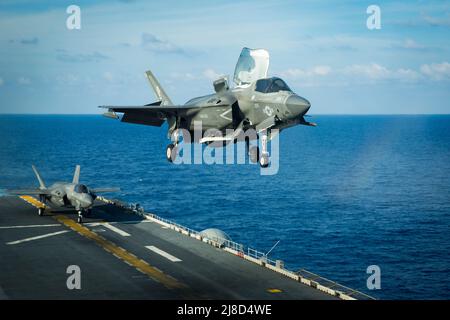 Ein US Marine Corps F-35B Lightning II Kampfflugzeug, das an die Dragons of Marine Medium Tiltrotor Squadron 265 angeschlossen ist, führt eine vertikale Landung auf dem Flugdeck des amphibischen Sturmschiffs USS America der amerikanischen Klasse durch, das am 18. April 2020 auf dem Südchinesischen Meer eingesetzt wird. Stockfoto