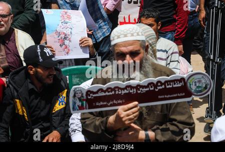 Ein Palästinenser trägt ein Schild mit der historischen Palästinenserkarte, während er an einer Kundgebung zum 74.. Jahrestag von Nakba vor den UNESCO-Büros in Gaza-Stadt teilnimmt. Die palästinensischen Fraktionen organisieren alle 15.. Mai eine Kundgebung, die das, was sie die "Nakba" oder "Katastrophe" nennen, mit Bezug auf ihre Entwurzelung im Krieg um die Gründung Israels im Jahr 1948 markiert. Stockfoto