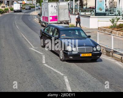 Ayia Napa, Zypern - 31. Mai 2021: Schwarzer Mercedes 6-türig Taxi-Auto auf Nissi Ave in der Innenstadt. Ayia Napa ist ein Touristenresort am östlichen Ende der Stockfoto