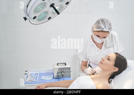 Frau mit Mole Entfernung Verfahren in Beauty-Klinik Stockfoto