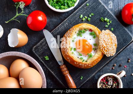Leckeres Eierfrühstück: In einem Brötchen gebackenes Ei. Draufsicht, flach liegend. Stockfoto