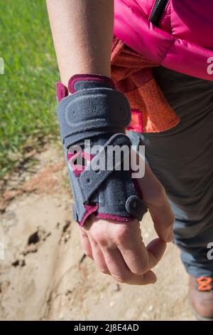 Kaukasische Frau, die eine Rutschschiene trägt, um ihre verletzte Hand zu schützen. Im Freien. Madrid. Spanien Stockfoto