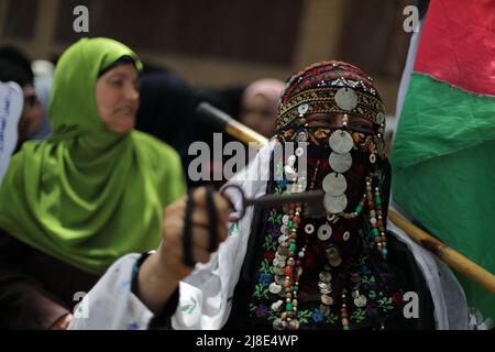 Gaza-Stadt, Palästina. 15. Mai 2022. Die Palästinenser schwenken ihre Nationalflaggen während einer Kundgebung zum 74h. Jahrestag dessen, was die Palästinenser die "Nakba" nennen, oder "Katastrophe", die sich auf ihre Entwurzelung im Krieg um die Gründung Israels im Jahr 1948 bezieht, vor den UNESCO-Büros in Gaza-Stadt. Kredit: Majority World CIC/Alamy Live Nachrichten Stockfoto