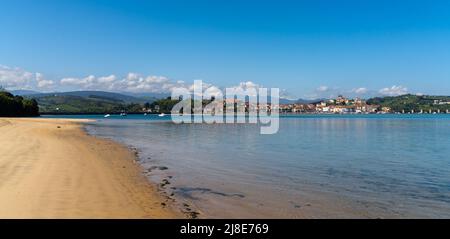 San Vicente de la Barquera, Spanien - 25. April 2022: Panoramablick auf den Maza-Strand und San Vicente de la Barquera mit den Picos de Europa-Bergen im b Stockfoto