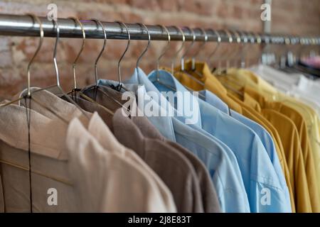 Bio-Öko-Kleidung auf Kleiderbügeln im Laden. Hausgemachte Kleidung aus natürlichen und verarbeiteten Stoffen. Stockfoto