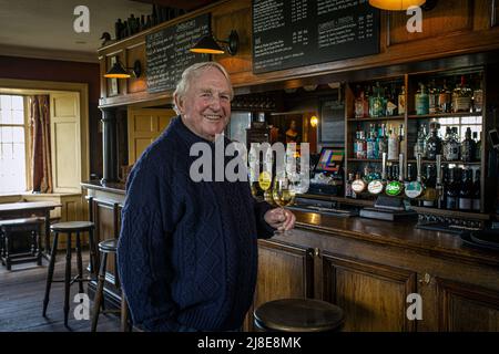 Reifer Rüde mit einem Glas Wein im Gunton Arms, North Norfolk, England Stockfoto