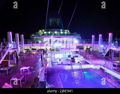 Bridgetown, Barbados - 25. März 2022: Eine Nachtfotografie des Poolbereichs auf dem obersten Deck an Bord des P and O Cruise Liners Britannia im Bridgetown Dock Stockfoto