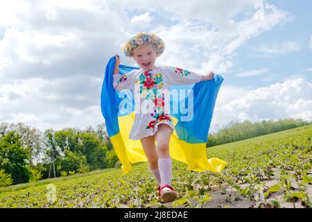 Wyschywanka Tag in der Ukraine. Flagge der Ukraine in den Händen des glücklichen Mädchens Ukrainisch. Kind mit ukrainischer Flagge. Unabhängigkeitstag. Wyschywanky-Welttag Stockfoto