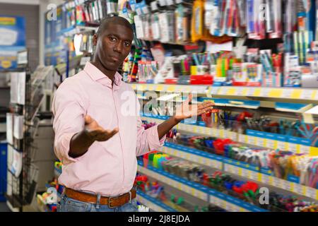 Junger afrikanischer Mann, der Stifte und Stifte auswählt Stockfoto