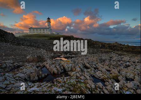 Der Südturm vor einem von einem Sonnenaufgang beleuchteten Himmel, Fair Isle Stockfoto