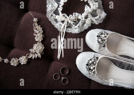 Drei Eheringe, Schuhe und andere Accessoires. Stockfoto