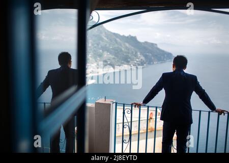 Der Bräutigam wartet auf die Braut auf dem Balkon. Stockfoto