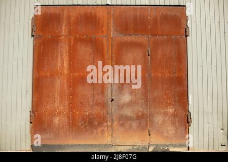 Rostige Tore. Große Stahltore. Rostetes Metall. Details zum Produktionsbereich. Stockfoto