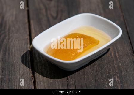 Selektive Fokusansicht der Platte mit Quitten-Marmelade auf einem Holztisch. Stockfoto