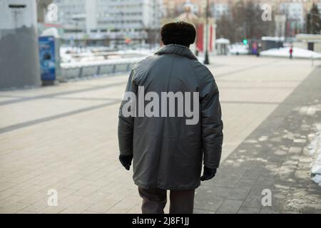 Alter Mann in Russland. Rentner auf der Straße. Mann von hinten. Großvater in der Stadt. Stockfoto