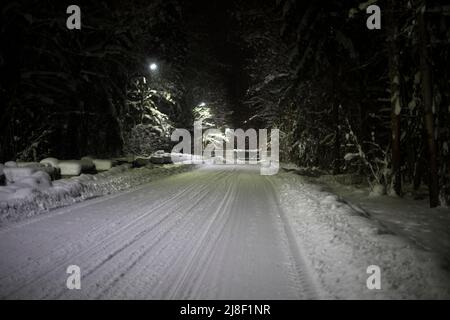 Straße im Winter. Schneebedeckte Straße in Wäldern. Viel Schnee auf der Strecke. Stockfoto