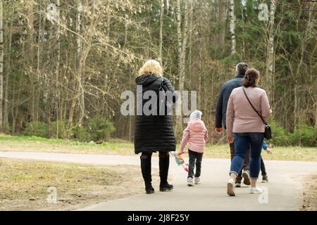 Familie auf einem Spaziergang im Park. Menschen in Russland. Männer und Frauen mit Kindern laufen bei bewölktem Wetter. Stockfoto