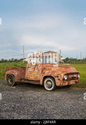 Klassischer alter rostiger Pick-up-Truck, der in einer felsigen Auffahrt in einer Stadt in Subburban geparkt ist Stockfoto