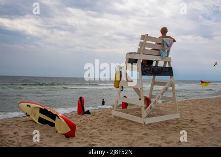 Strandlifegard auf einem Hochsessel mit Blick auf das Meer Stockfoto