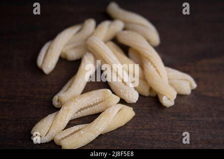 Ungekochte trockene Casarecce Pasta auf dunkler Holzoberfläche Stockfoto