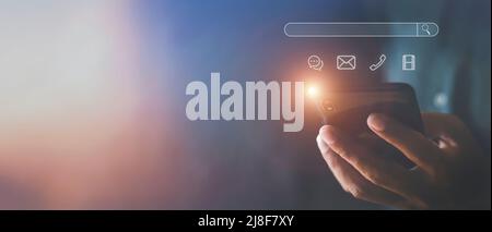 Hand des Mannes mit Mobiltelefon mit Suchleiste Symbol Social Media und Social Network Online-Marketing-Konzept Mann Hand hält Smartphone mit Icon Lif Stockfoto