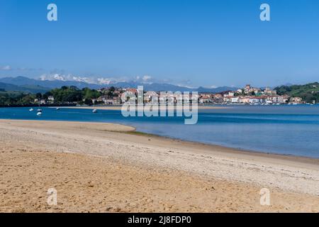 San Vicente de la Barquera, Spanien - 25. April 2022: Panoramablick auf den Maza-Strand und San Vicente de la Barquera mit den Picos de Europa-Bergen im b Stockfoto