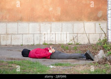 Eine tote Ukrainerin liegt auf der Straße mit ihren Händen an einem weißen Seil gebunden und wurde in der Ukraine, einem Todesprotest in der Stadt, im Rücken getötet Stockfoto