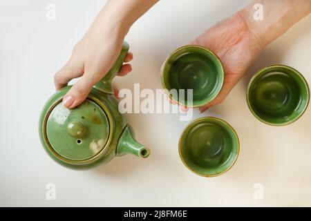 Frau Hände halten Teekannen Tischansicht. Heiße Tasse gesunde Getränke. Lifestyle Frau entspannen flach legen Stockfoto