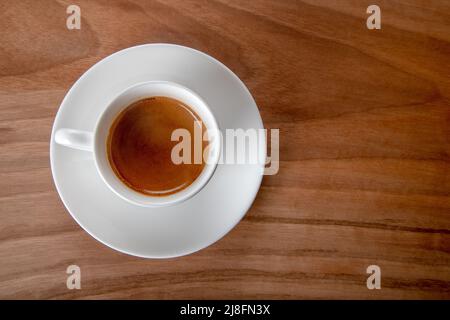 Weiße Tasse Espresso auf Holzhintergrund, Draufsicht Stockfoto