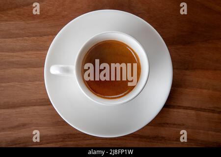 Weiße Tasse Espresso auf Holzhintergrund, Draufsicht Stockfoto