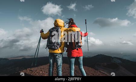 Rückansicht von ein paar Wanderern mit Rucksack und Stöcken beobachten das Panorama vom Gipfel des Ätna in Sizilien, Italien - die wichtigsten europäischen aktiv Stockfoto