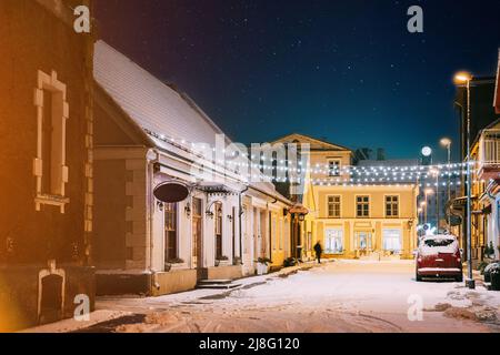 Parnu, Estland. Nächtliche Aussicht Auf Die Straße Mit Alten Gebäuden, Holzhäusern, Restaurants, Cafés, Hotels Und Geschäften Im Winter Abendbeleuchtung Stockfoto