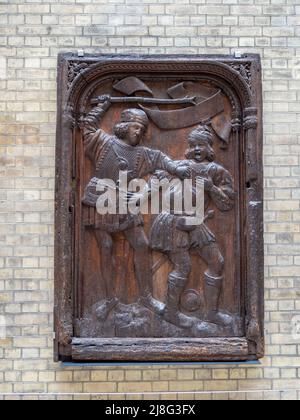 Eichenholztafel aus dem 16.. Jahrhundert aus Frankreich, von der angenommen wird, dass sie die Bestrafung eines bei der Tat gefangenen Räubers darstellt, wird im V&A Museum, London, Großbritannien, ausgestellt Stockfoto