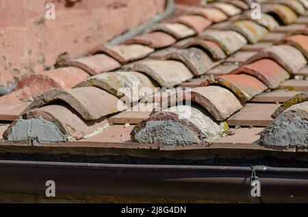 Haus: Gebäude mit Dachschräge mit Ziegelsteinen, Dachrinne aus freiliegendem Blech. Die Schindeln sind aus Lehm, mit einer selbstsichernden Form. Stockfoto