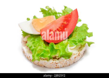 Reiskuchen-Sandwich mit Tomaten, Salat und Ei - isoliert auf Weiß. Einfaches Frühstück. Diät-Essen. Schnelle und gesunde Sandwiches. Knäckebrot mit leckerer Füllung. Gesunde Ernährung Snack - Isolation Stockfoto