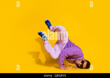 In voller Länge Körpergröße Ansicht der attraktiven trendigen Kerl tanzen niedrige Bremse Training isoliert auf hellen gelben Hintergrund Stockfoto
