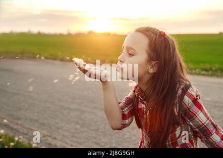 Mädchen bläst auf einen Dandelion Stockfoto