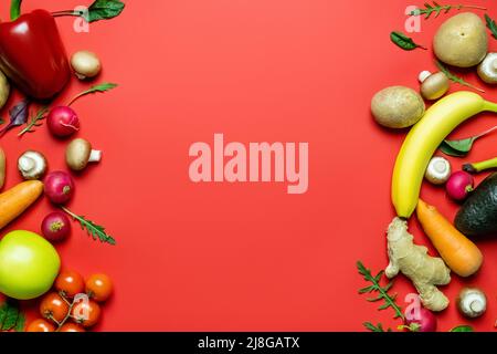 Flach mit Gemüse und Obst auf rotem Hintergrund mit Platz zum Kopieren legen Stockfoto