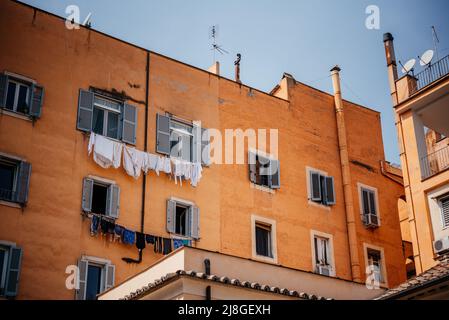 Italienisches Haus mit Fenstern mit Rollläden und Wäschestauken am Seil unter den Fenstern Stockfoto