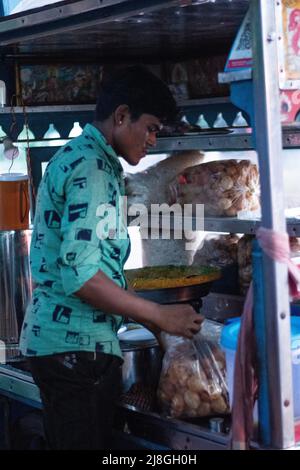 Ein Bild eines Straßenverkäufers, der bhel puri in indischen Straßen verkauft (Bhelpuri ist ein herzhafter Snack aus Indien und auch eine Art Chaat) Stockfoto
