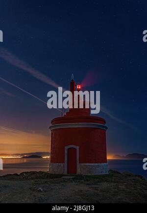 Landschaftsansicht auf dem ikonischen roten Leuchtturm in Punta Robaleira, in Cabo Home, Cangas, Spanien Stockfoto