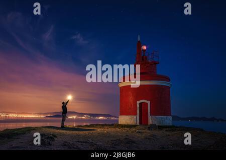 Landschaftsansicht auf dem ikonischen roten Leuchtturm in Punta Robaleira, in Cabo Home, Cangas, Spanien Stockfoto