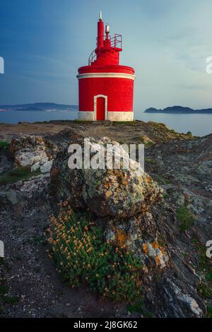 Landschaftsansicht auf dem ikonischen roten Leuchtturm in Punta Robaleira, in Cabo Home, Cangas, Spanien Stockfoto